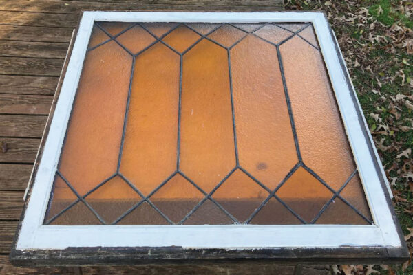 Stained glass panel in window sash before restoration